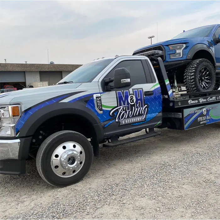 M&H Towing and Recovery Tow Truck services towing a Ford Raptor Truck