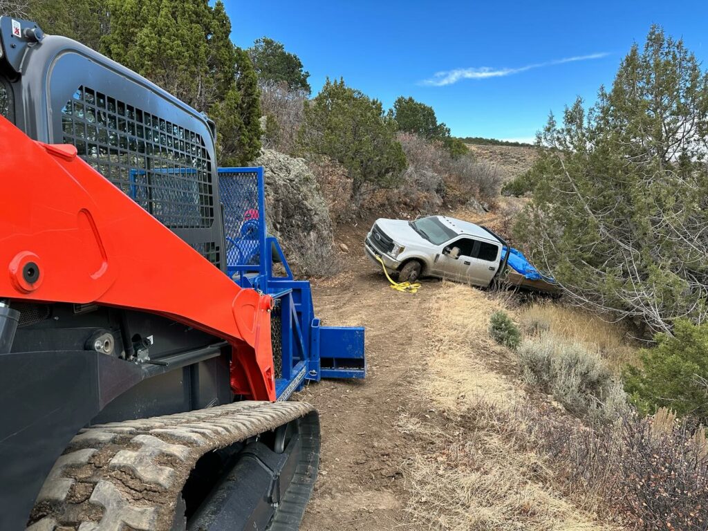 Off Road Recovery using a skid steer in Buckhorn, CO by M&H Towing and Recovery.